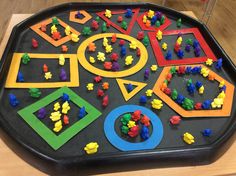 a child's play table with lots of toys and letters on it in the shape of shapes