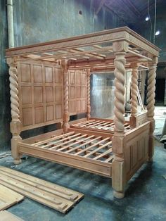 a wooden bed frame sitting on top of a floor next to some wood planks