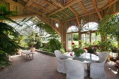 the inside of a house with plants and chairs