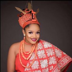 a woman in an orange and white dress with a crown on top of her head