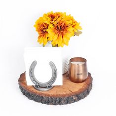 a vase with flowers and a pair of horseshoes sitting on a wooden stand next to it