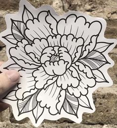 someone holding up a sticker with a flower on it