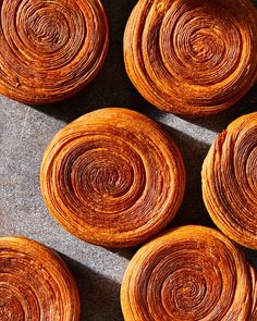 several orange pastries sitting on top of a table next to each other in the shape of spirals