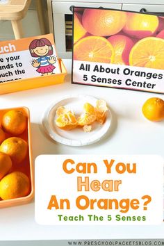 an orange is sitting on a table next to two boxes with signs that say, can you hear an orange? teach the 3 sense