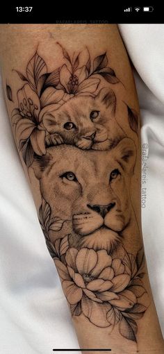 a woman's arm with a lion and flowers on it