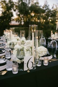 the table is set with candles, flowers and place cards for guests to sit at