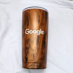 a close up of a wooden cup on a white surface with google written on it