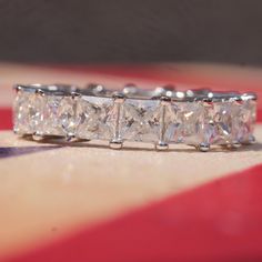 a diamond ring sitting on top of a red and white checkered table cloth,