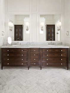 a large bathroom with double sinks and two mirrors on the wall next to each other