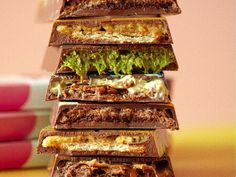 a stack of chocolate sandwiches sitting on top of a table next to a pink bowl