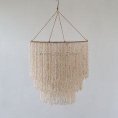 a chandelier hanging from a rope with beads on it's end and bottom