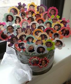 a bucket filled with lots of different pictures on top of a window sill