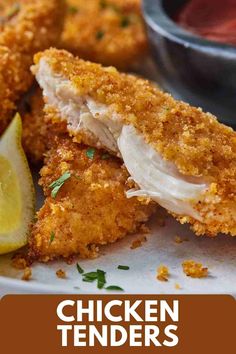 chicken tenders on a plate with lemon wedges and ketchup in the background