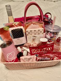 a pink basket filled with personal care items on top of a white sheet covered bed