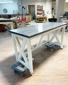 a workbench in the middle of a workshop with tools and materials on it