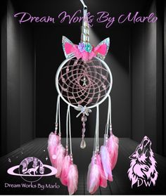 a dream catcher with pink feathers and a unicorn on it's head that says dream wolf big mama