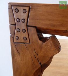 a close up of a wooden bench with holes in it