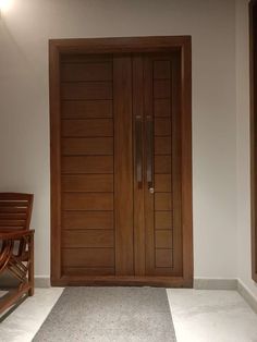 a large wooden door sitting next to a chair on top of a carpeted floor