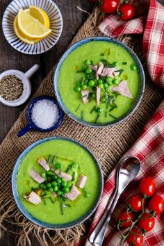 two bowls filled with green pea soup and garnish