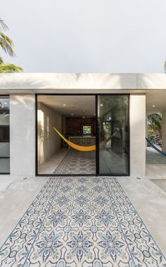 an outdoor area with a hammock hanging from the ceiling and tiled flooring