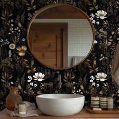 a bathroom sink sitting under a round mirror next to a wooden cabinet and counter top