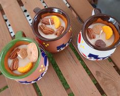 two cups filled with food sitting on top of a wooden table next to each other