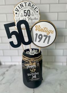 a 50th birthday cake topper in a mason jar