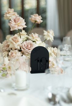 the table is set with flowers and candles for an elegant wedding reception in black, white and pink