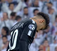 a soccer player with his head down in front of an audience at a game,