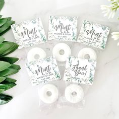 four rolls of white washi tape sitting on top of each other next to a plant