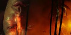 a close up of a man's face with fire coming out of his eyes