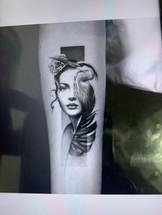 a black and white photo of a woman's arm with a cross on it