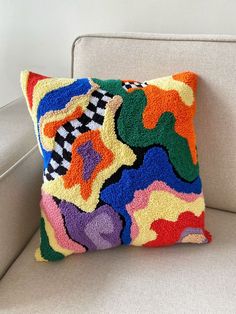 a multicolored pillow sitting on top of a couch