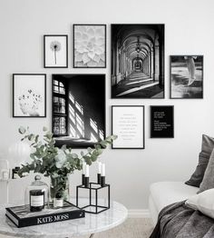 a living room with white walls and pictures on the wall