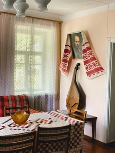 a room with a table, chairs and pictures on the wall