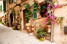 an old building with flowers on the outside wall