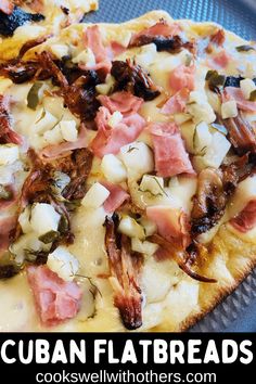 a pizza with ham, cheese and other toppings on it sitting on a plate