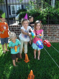 several children are playing with toys in the yard