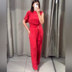 New With Tag Jumpsuit With Flowy Neckline And Asymmetric Sleeve. Self-Belt With Gold Buckle. Wide Leg. Back Hidden In-Seam Zip Closure With Opening And Button. Outer Shell 100% Polyester Lining 100% Polyester Red / Coral | 2298/155 Summer Evening Overall Pantsuit, Summer Evening Pantsuit Overall, Asymmetrical Jumpsuits And Rompers For Summer Workwear, Asymmetrical Summer Jumpsuits And Rompers For Work, Asymmetrical Jumpsuits And Rompers For Evening Summer Events, Asymmetrical Summer Evening Jumpsuits And Rompers, Elegant Zara Jumpsuits And Rompers, Elegant Red Summer Pantsuit, Zara Sleeveless Jumpsuits For Evening