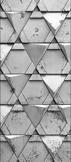 a black and white photo of a wall made up of triangles with paint chippings