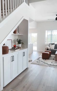 a living room filled with furniture and a staircase leading up to the second floor area