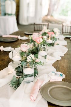 a long table is set with candles and flowers in glass vases on the tables