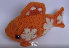 an orange and white knitted toy fish laying on top of it's side