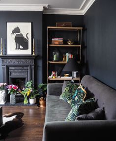 a living room filled with furniture and a fire place in front of a book shelf