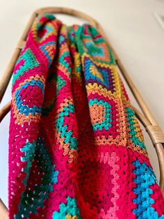 a crocheted blanket sitting on top of a wooden chair