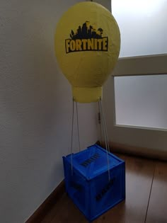 a yellow balloon with the word fortnite on it is attached to a blue box