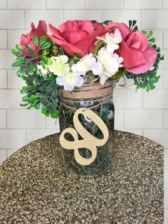 a mason jar filled with flowers on top of a granite table next to a white brick wall