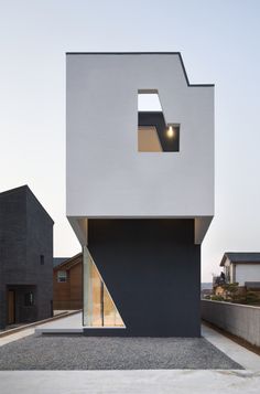 the house is made up of black and white blocks, with an open window at the top