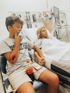 a man and woman sitting in a hospital bed with blood all over their face,