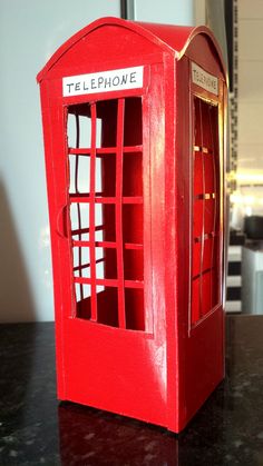 a red phone booth sitting on top of a table